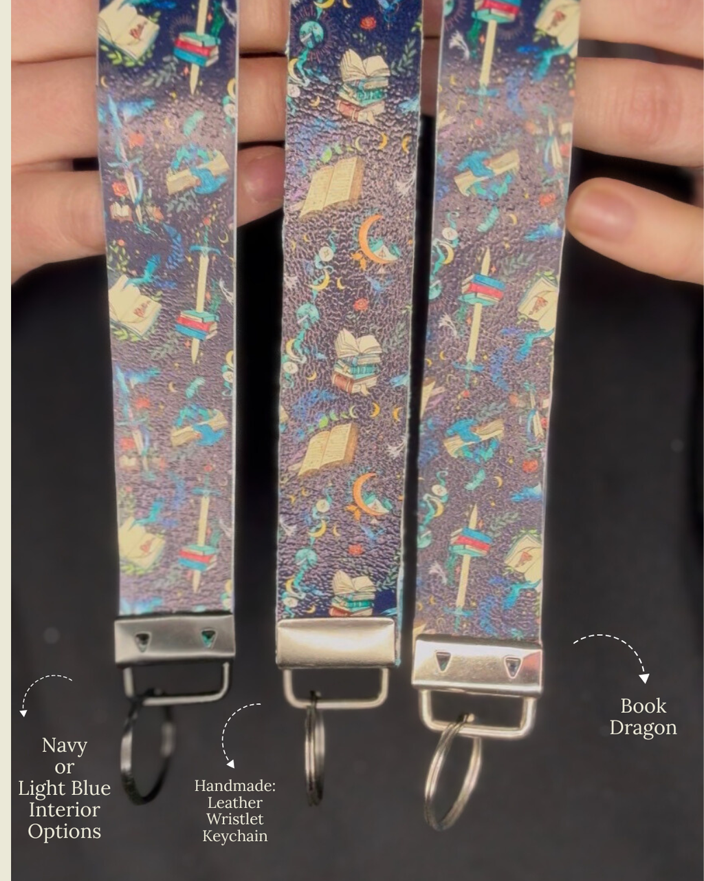 Three keychain straps with a book-themed pattern held by hands against a black background.