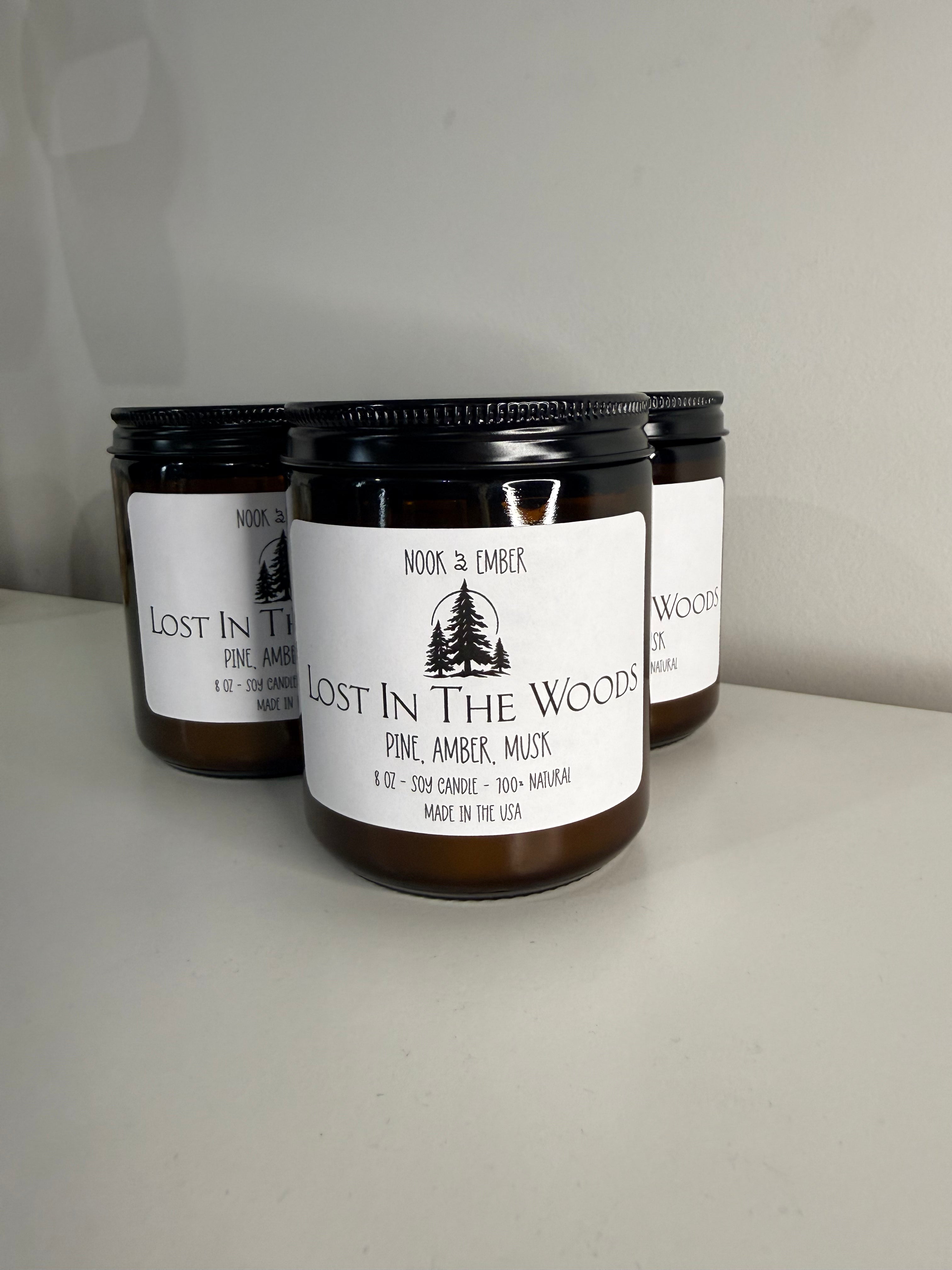 Three candles in amber glass jars with white label: tree's 