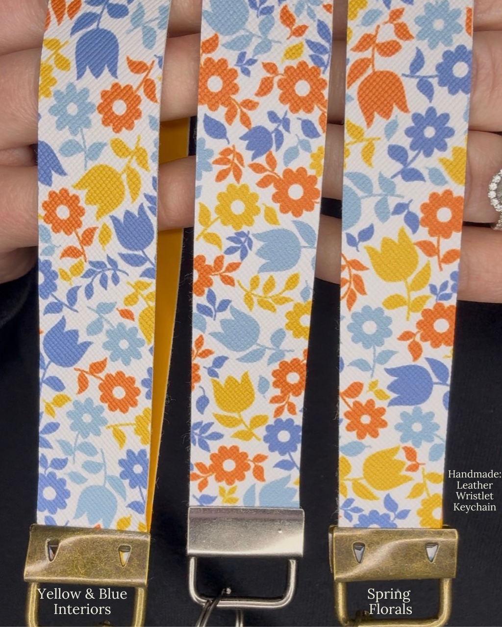 Floral patterned leather wristlet with gold clasp held by a hand