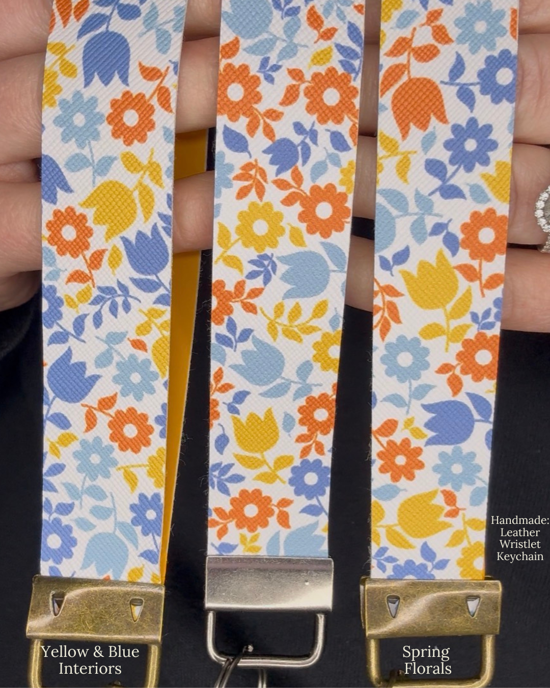 Floral patterned leather wristlet with gold clasp held by a hand